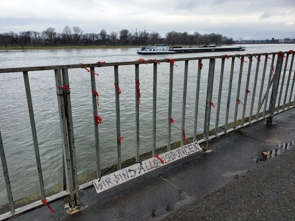 Photo of the Rhine with urban art sign that says "We are all connected".